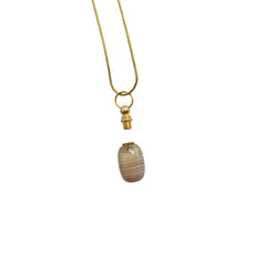 Close-up of ocean chalcedony agate cremation pendant unscrewed to reveal small inner chamber for ashes or keepsakes.