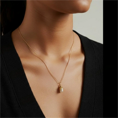 Model wearing ocean chalcedony agate urn necklace, gold chain resting elegantly on the neckline, minimalist memorial jewellery style.