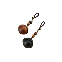 Pair of planet-shaped wooden mini urn keychains for ashes, one walnut and one black, with braided loop and bead accents