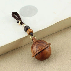 Brown wooden planet urn keychain on book — walnut tone