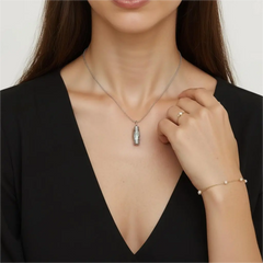 Snow Ridge micro-engraved ashes necklace worn by model — small sterling-silver cremation urn pendant on snake chain.