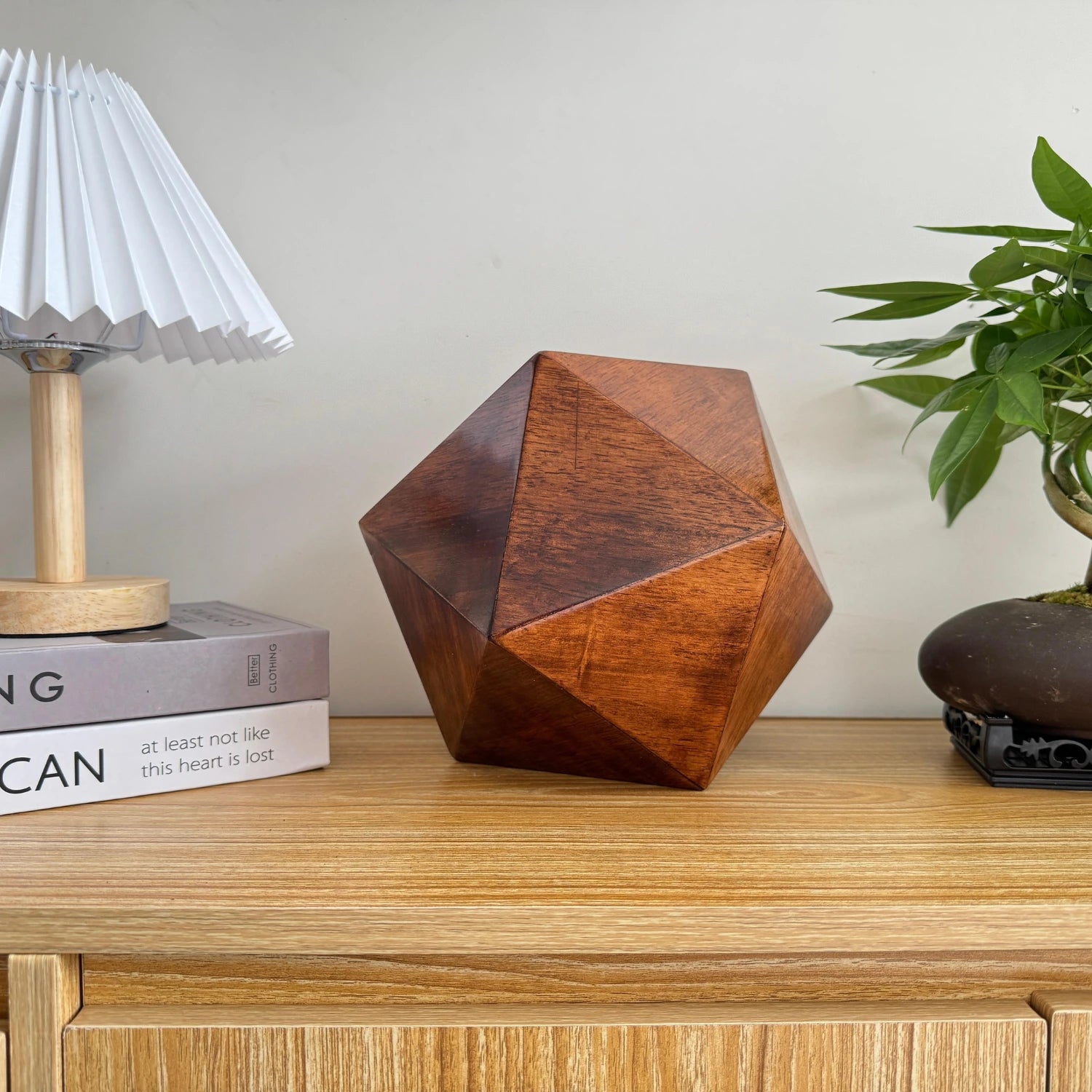 Solace Pet Urn — geometric walnut icosahedron urn displayed on a modern shelf